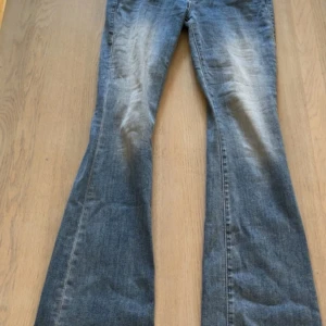 Fina True Religion Jeans! - Snygga ljusblå jeans från True Religion, modell Becca med bootcut och midwaist. Klassiska fickor med lock och silverfärgade knappar bak, coola slitningar framtill och mjukt denimtyg. Perfekt passform och trendig look. Använda, men är fortfarande i gott skick!