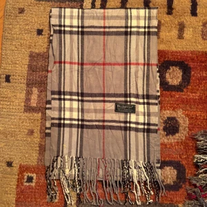Vintage Burberry Scarf halsduk  - -Riktigt bra skick. Nypris på dessa ligger på runt 5000kr, vilket gör detta till ett sjukt bra pris! Halsduken är gjord i Lamull, och är perfekt inför hösten och den kommande vintern. Anledningen till att det står ”Burberry’s” och inte ”Burberry” på lappen är eftersom halsduken är från några år tillbaka, innan de bytte namn! Om du har någon fråga är det bara att skriva till mig. /elgnce (4)
