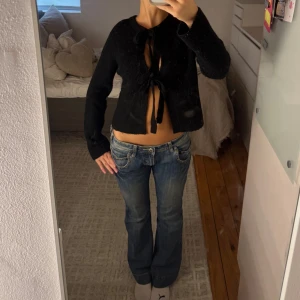 Blå bootcut jeans med nitar - Säljer ett par riktigt snygga blå jeans med bootcut passform och låg midja. Jeansen har slitningar och coola nitar på fickorna fram. Perfekt för dig som gillar detaljer och en avslappnad stil. Midjemått: 39 cm. Innerbenslängd: 81cm. Mätt platt rakt över 