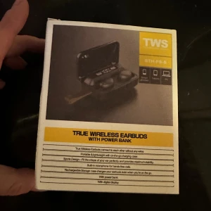 True Wireless Earbuds AirPods Trådlösa Hörlurar med Power Bank -  True Wireless Earbuds med laddningsetui som även fungerar som powerbank. Utrustade med digital display, touchkontroll och inbyggd mikrofon för handsfree-samtal. Sportig design, lätta och portabla. Produkten är ny i förpackning.Säljer ett par trådlösa hörlurar av modellen TWS BTH-F9-5. De är utrustade med power bank, digital display, touch control och hands-free funktion.