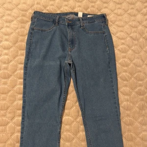 Skinny jeans i ljusblå denim - Snygga skinny jeans från &Denim i mer mörkblå ton. Modellen har regular waist och ankellängd, vilket ger en modern och fräsch look. Klassisk femficksdesign och smal passform som sitter tajt hela vägen ner. (Motsvarar storlek M/L)