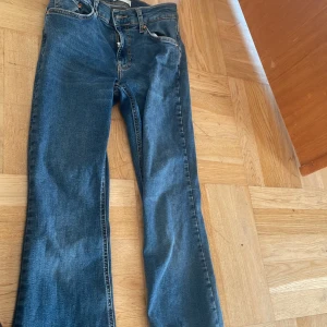 Blå bootcut jeans från Gina tricot  - Snygga blå jeans från gina tricot i klassisk bootcut-modell. Jeansen har fem fickor, dragkedja och knapp framtill samt kontrastsömmar. Materialet är mjukt denim som sitter skönt och har en lätt utsvängd passform nedtill. Perfekt för dig som gillar retrovibbar och vill ha en cool siluett. Använd 2-3 gånger . 