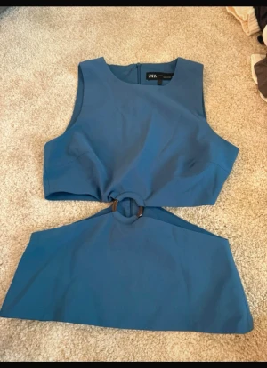 Blå cut out topp  Zara - Säljer en blå croppad topp från Zara med ärmlös design och rund hals. Toppen har en snygg ringdetalj i midjan. Skriv vid frågor💞