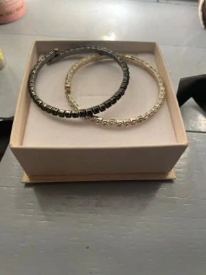 Armband - Bilderna visar två armband, ett i svart och ett i silver, med fyrkantiga stenar. Kontakta mig om du är intresserad av ett armband istället för båda🤍