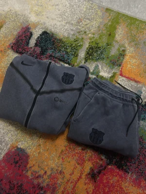 En mörkblå tracksuit från nike med barca och nike loga - En jätte snygg barcelona tracksuit perfekt för alla väder man kan ha när som helst logan ser perfekt ut den är lite använd 