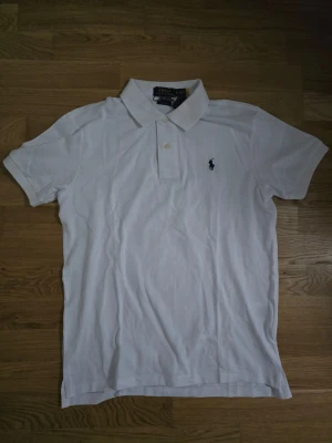 Vit pikétröja Polo Ralph Lauren - Klassisk vit pikétröja från Polo Ralph Lauren med svart broderat märke på bröstet. Helt ny och priset är ej hugget i sten. 