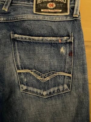 Replay Anbass Jeans - Ljusblå Replay Anbass Jeans med snygga slitningar. Storlek: W33 L32