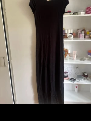 Svart tajt lång klänning  - Sprillans ny svart, kortärmad, tajt och lång klänning från nelly i storlek S. Väldigt fin och passar bra till allt. Kan användas under sommaren och under vintern om man tillexempel har någon kofta över.💕