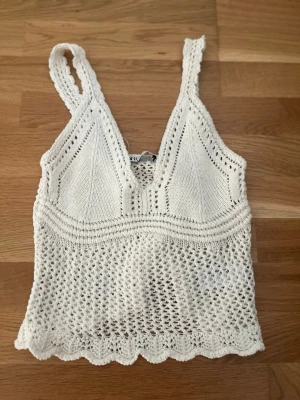Vit stickad linnetopp från Zara - Säljer en vit virkad linnetopp från Zara med breda axelband och v-ringad hals