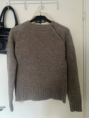 Brun stickad tröja  - Säljer den här brungrå stickade tröjan med coola silverspännen! Har aldrig kommit till användning, köpt här på Plick! Fin höstfärg och varm och skön✨🥰