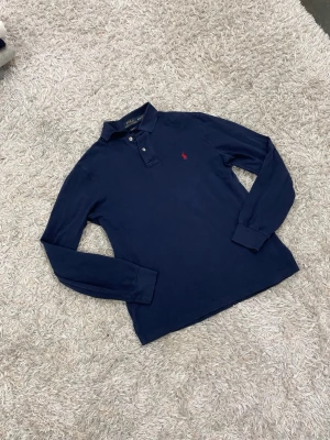 Polo Ralph Lauren tröja/långärmad krage blå storlek M - En väldigt snygg långärmad tröja från Ralph Lauren med en stilig krage. Tröjan är i ett otroligt fint skick och har inga skador alls✅✅🙌 vid frågor/prisförslag tveka inte med att höra av dig😇storlek M. OBS KOLLA IN FLERA PLAGG I PROFILEN🫡🫡