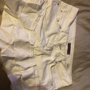 Vit jeanskjol från LTB - Snygga vita jeanskjol från LTB med råa kanter och klassiska fickor. Kjolen har en cool bakficka med broderad detalj och knapp, samt lågmidjade passform. Perfekta för sommarens alla äventyr och lätta att matcha med allt.