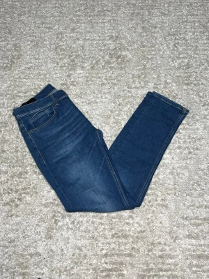 Dondup George  - Hej jag säljer ett par Dondup George i nyaste modellen. Jeansen i riktigt snygg blå färg perfekt för dig som vill ha ett par kvalitetsjeans med grym passform. Nypris ≈4000kr, mitt pris 899kr.  Skick: 9/10 Storlek: W34 Midja: 43cm Lår: 26cm Ytterlängd: 105cm Innerlängd: 79cm  Skriv gärna om du vill ha fler bilder eller har frågor!