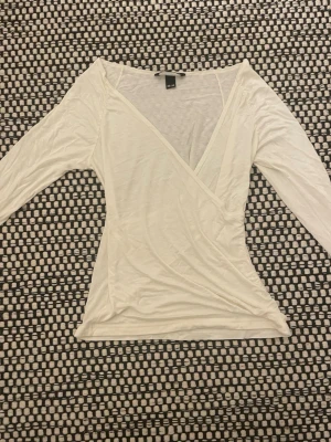 Vit omlottopp från H&M - Säljer en vit omlottopp från H&M i storlek 36-38. Toppen har lång ärm och djup v-ringning. ⚠️Priset går att diskutera⚠️Aldrig andvänd för den var förstor