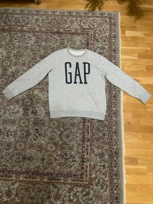 Grå tröja, storlek S - Säljer en grå sweatshirt från GAP i storlek S. Den är väldigt varm och passar därför vintern bäst. Jag har använt den en gång eftersom den är lite för stor för mig, så därför är den helt ny!