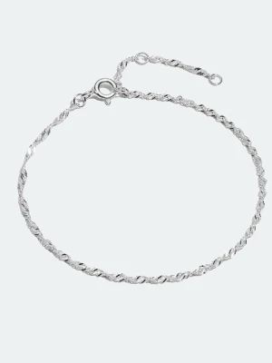 Silver armband  - Säljer ett tunt och stilrent armband i silverfärg med tvinnad kedja. Armbandet har en enkel ringlås och passar perfekt om du gillar minimalistiska smycken. Snyggt att bära ensam eller att kombinera med andra armband.