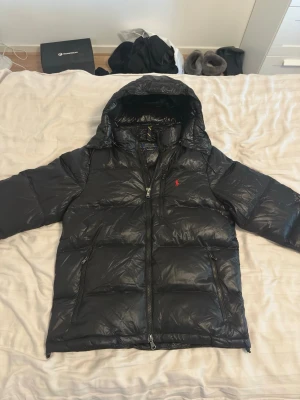 Ralph Lauren Jacka - Ralph Lauren Glossy jacka i storlek Medium. Jackan är helt oanvänd och i nyskick utan defekter. Säljes då den inte kommer till användning. Hör gärna av dig vid frågor eller funderingar! 