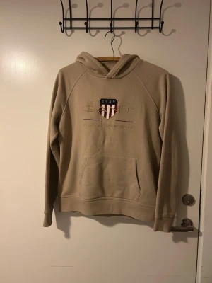 Gant Hoodie stl M - Denna hoodie är från Gant och är ett stilrent vardagsplagg i klass. Perfekt för dig som vill ha på dig sköna kläder, men samtidigt vara elegant.  Använd endast ett fåtal gånger, som ny. Hör gärna av dig vid frågor!😊 (Köpt för 900kr)