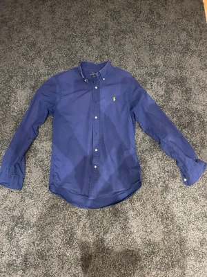 Polo Ralph lauren skjorta  - Skjorta från Ralph lauren i okej skick. Rätt så använd som ni ser på bilderna! Hör av dig vid frågor!
