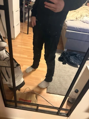 Svarta straight jeans från jack and Jones  - Säljer ett par svarta jeans från Jack and Jones  med klassisk straight passform. Byxorna har fem fickor och knappgylf, och är tillverkade i slitstarkt jeanstyg. Perfekt för dig som gillar en enkel och tidlös look. Passar dig som är 175-180. Iprincip helt nya 