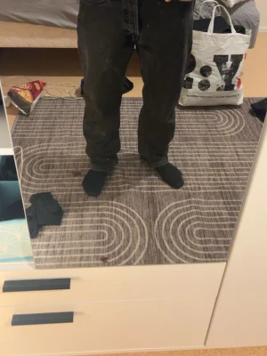 H.M svarta  jeans straight fit - Svarta HM har en mörk tvätt och är tillverkade i slitstarkt bomullsmaterial. Passformen är normal och midjan är midwaist. Perfekt för dig som gillar tidlös stil och vill ha ett par jeans som funkar till allt. Den är 32 i waist däremot så är den lite för stor så passar bättre som 34-35 i waist