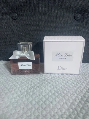 Miss Dior Parfum 80ml - Miss Dior Parfum från Dior, 80ml. Snygg flaska med silverrosett och exklusiv design. Perfekt för dig som vill ha en ikonisk och trendig parfym i din samling.