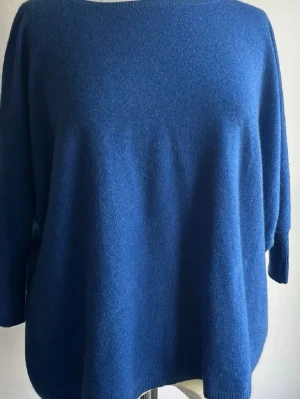 Blå oversized stickad tröja från Soft Goat - Mysig oversized stickad tröja i en djup blå färg. Tröjan har rund halsringning och långa ärmar med breda muddar. Perfekt för lager på lager och chill dagar. Passformen är loose och materialet känns mjukt och värmande.