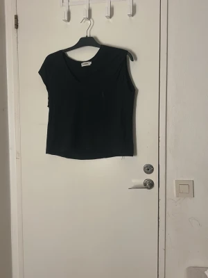 Svart v-ringad topp från Sweewë - Pris kan diskuteras och tvätt ingår innan leverans 💗Svart, stilren topp från Sweewë i storlek M. Modellen är ärmlös med v-ringad hals och rak passform. Perfekt att matcha med jeans eller kjol för en enkel och snygg look. Materialet känns mjukt och lätt mot huden.