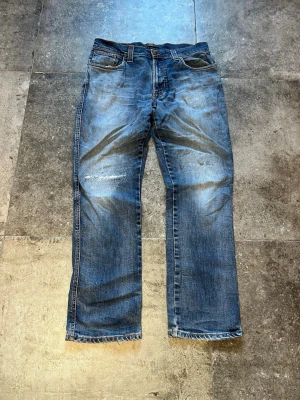 Flared Nudie Jeans - Slim Jim - Tja! säljer mina slim jim’s i 34/32 (sitter mer som 32/32)👏 passformen är en straight / flared och de har en helt sjuk wash🫡 tveka inte på att skriva ifall ni har fler frågor✌️