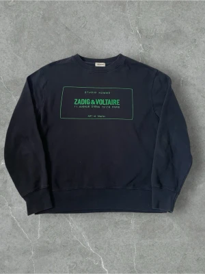 Svart sweatshirt Zadig & Voltaire | M - Cool svart sweatshirt från Zadig & Voltaire med grön text och print framtill. Klassisk rund halsringning och långa ärmar. Tillverkad i mjuk bomull som känns skön mot huden. Perfekt för dig som gillar stilrena och trendiga plagg med en twist.