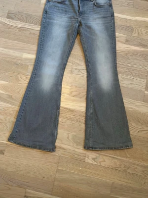 Flame bootcut jeans Weekday - Säljer ett par gråa bootcut jeans från Weekday i modellen Flame low waist. Storlek  W29 L32. De har klassisk femficksmodell och snygga slitningar. Köpte dem i Stockholm för 599 men min storlek var tyvärr slut. De är uppsydda för att passa mig på 165 cm, men inget tyg har klippts bort och det går att backa med en sprättkniv eller nagelsax. Kan göra det åt dig om du vill, Jeansen blir då ca 3 cm längre. De är använda 3-4 gånger och har inga tecken på slitage. Pris kan diskuteras 🫶🏻