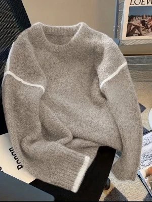 Grå stickad tröja med vita detaljer - Mysig grå stickad tröja med rund hals och vita ränder längs ärmarna samt vid ärmsluten. Perfekt för lager-på-lager och chill dagar. Tröjan har en relaxed fit och långa ärmar.