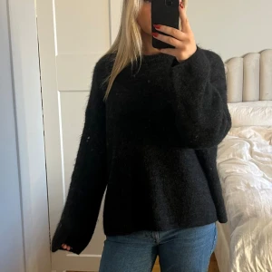 Svart stickad oversized tröja - Mysig svart stickad tröja med oversized passform och långa ärmar. Polyamid 33% Mohair 32% Ull 32% Elastan 3%