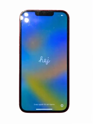iPhone 13 (PRODUCT)RED - Snygg röd iPhone 13 med dubbla kameror. Skärmen har några repor och baksidan är sprucken i hörnet, men telefonen fungerar bra. Face ID och modern design. 256 GB