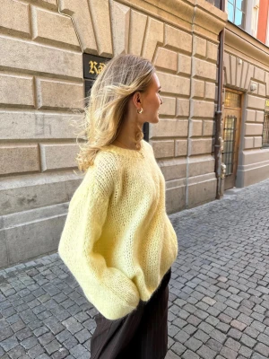 Gul stickad oversized tröja - Supermysig stickad tröja i ljusgul färg med oversized passform och långa ärmar. Tröjan har en enkel rund halsringning och är gjord i ett fluffigt, stickat material som känns både trendigt och bekvämt. Perfekt att slänga på sig när det är lite kyligare ute.