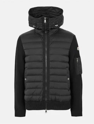 Moncler pufferjacka - Svart pufferjacka från Moncler med stickade ärmar och quiltad kropp. Jackan har huva, tvåvägsdragkedja och ficka med dragkedja på ärmen. Materialmix av polyester och stickad ull ger en schysst kontrast. Perfekt för dig som gillar stilren och sportig look. Storlek S men passar även M utan problem kvitto finns.