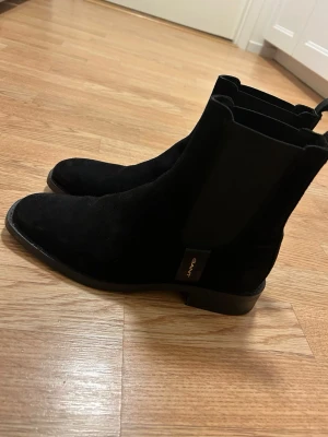 Svarta  boots i mocka från Gant - Säljer ett par  svarta  boots från Gant i mjuk mocka. Använda en enda gång. Storlek 39. Kan tänka mig gå ner i pris. 