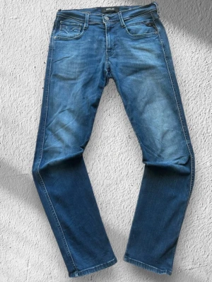 Blå Replay Anbass Jeans - Klassiska Replay Anbass jeans i blå tvätt. Jeansen är i mycket bra skick och sparsamt använda. Anbass är slim fit!  Storlek: W30/L30 (normal i storleken) Skick: Mycket bra skick! Färg: Blå Märke: Replay Modell: Anbass  Hör gärna av dig vid frågor så svarar jag så fort jag kan! 😁   
