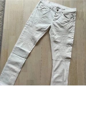 Vita jeans dondup George  - Säljer ett par vita jeans från Dondup, modell George med slitna detaljer framtill. Klassisk femficksmodell med diskret Dondup logga på bakfickan och röd märkning i linningen. Snygg passform och stretchigt bomullsmaterial som sitter fett. Jäkligt schyssta och extremt bra skick utan några defekter, säljer för ett schysst pris! Bara att höra av sig vid frågor!