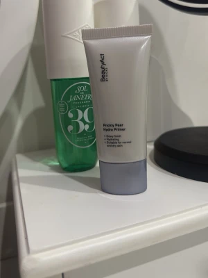 BeautyAct Prickly Pear Hydra Primer - Säljer en BeautyAct Prickly Pear Hydra Primer i en stilren vit tub med grått lock. Primern ger en dewy finish och är återfuktande, används på torr hud! Inte använd 