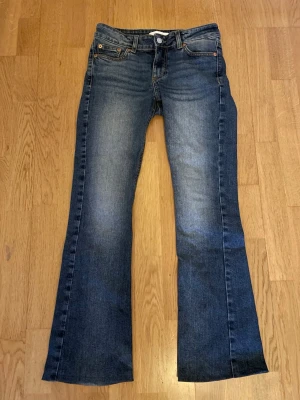 low waist bootcut jeans - säljer dessa mörkblå low waist bootcut Junkyard jeans som inte kommer till någon användning längre. Byxorna är uppsydda och passar perfekt på mig som är 160cm. Det syns inte att de är uppsydda då tråden är precis samma färg som jeansen.  Midjemått: 36cm Innerbenslängd: 71cm Ytterbenslängd: 93cm