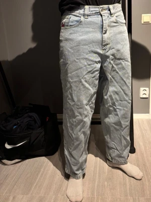 Big Boy ljusblå baggy jeans XS - Säljer ett par ikoniska Big Boy jeans i ljusblå tvätt. De har en riktigt baggy passform med raka ben, klassiska fem fickor och tydliga gula sömmar. Jeansen är tillverkade i slitstark denim och har en blå etikett bak i midjan med Big Boy-loggan.