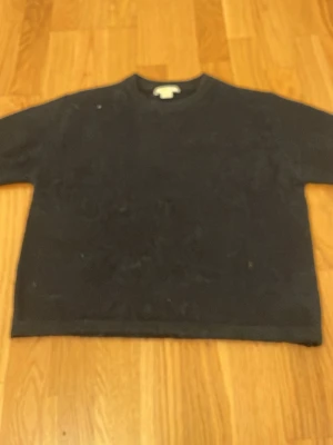 Mörkblå nästan svart stickad tröja från Gina - Mysig mörkblå nästan svart stickad tröja från Gina Tricot i enkel design. Tröjan har rund halsringning och korta.Passformen är normal och materialet känns mjukt och skönt mot huden.storlek 146-152