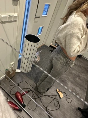 Grå raka jeans med låg midja - Säljer ett par grå jeans med låg midja och raka ben. Jeansen har klassisk femficksdesign och knäppning fram. Perfekta för en avslappnad och trendig look. Passar dig som gillar en loose fit och vill ha ett par stilrena basjeans.