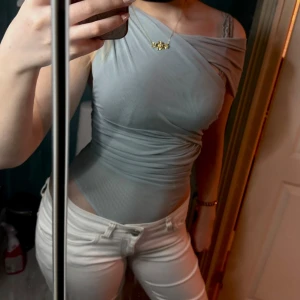 Ljusblå oneshoulderbody från zara - Storlek S men passar även M💗Säljer en ljusblå, tight body med one shoulder-design. Tyget är stretchigt och sitter figurnära med snygga draperingar på sidan. Perfekt för dig som gillar en stilren och modern look.