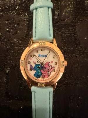 Helt ny Stitch klocka för barn - Bilderna visar en klocka med Stitch-motiv och turkos armband. Kommer från ett djur och rökfritt hem. 