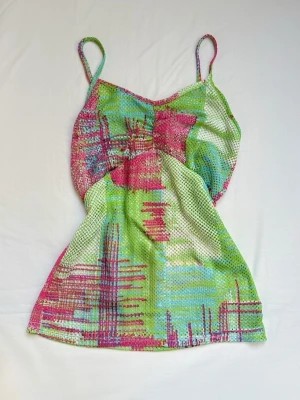Färgglad mesh linnetopp - Säljer en färgglad linnetopp i mesh med tunna axelband. Toppen har ett rutigt mönster i grönt, rosa, blått och vitt. Perfekt för sommaren