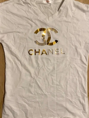 Vit t-shirt med Guld tryck - Vit t-shirt i mycket bra skick och är i storlek M
