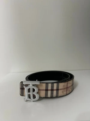 Burrbery Bälte - Säljer ett äkta Burberry-bälte i klassiskt rutigt mönster. Bältet är i mycket fint skick och har använts sparsamt. Tidlös design som passar perfekt till både vardag och finare outfits. Storlek 105. Original Burberry-spänne.