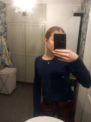 Mörkblå långärmad tröja - En basic mörkblå långärmad tröja med rund halsringning. Tröjan har en enkel och stilren design utan synliga detaljer eller mönster. Perfekt att matcha med jeans eller kjol för en clean look.